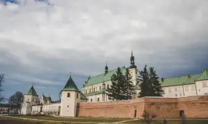 Bazylika w Leżajsku, jedna z głównych atrakcji, z zielonymi dachami i ceglanym murem obronnym.