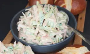 Ein cremiger Fleischsalat, perfekt für ein schnelles **Fleischsalat Rezept**. Serviert mit Laugenbrötchen.