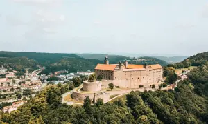 Die Plassenburg thront über der Kulmbach Altstadt, umgeben von grünen Hügeln. Ein malerischer Anblick!