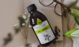 Butelka z naturalnym, nierafinowanym olejem z wiesiołka, idealnym do pielęgnacji włosów. Delikatne kwiaty podkreślają jego naturalne pochodzenie.