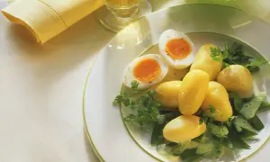 Ein einfaches zuckerschoten rezept: Salzkartoffeln, hartgekochte Eier und Zuckerschoten mit Kräutersauce auf einem Teller.