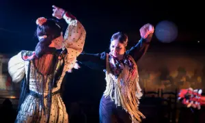 Dos mujeres bailan flamenco, el baile típico de España, con pasión y gracia. Sus trajes vibrantes y movimientos expresivos capturan la esencia de esta arte.