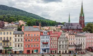 Kolorowe kamienice i kościół z zieloną wieżą tworzą malowniczy krajobraz. Odkryj teraza ruda atrakcje, spacerując po urokliwym rynku.