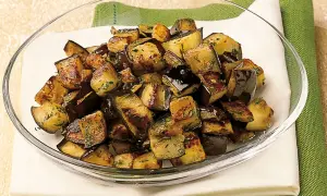 Melanzane a funghetto ricetta della nonna: cubetti dorati e saporiti, conditi con erbe aromatiche, pronti per essere gustati.