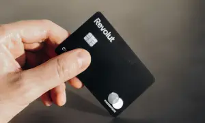 Dłoń trzyma czarną kartę Revolut Business z logo Mastercard.