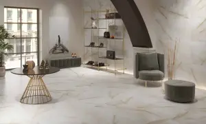 Elegantes suelos pintados con pintura imitan mármol veteado, complementando un salón moderno con estanterías doradas y mobiliario de terciopelo.