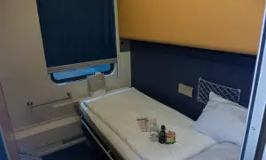Gemütliches Bett im Nachtzug Berlin Wien. Kleine Flaschen und eine Tüte liegen bereit.