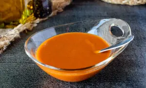 Un cuenco de cristal con una deliciosa salsa americana anaranjada, lista para acompañar tus platos.