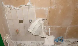 Renovierungsarbeiten: alte Fliesen werden entfernt, um Platz für neue zu schaffen. Staub und Schutt bedecken den Boden.