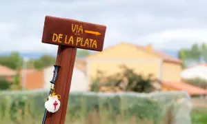 Drewniany drogowskaz Via de la Plata z muszlą pielgrzyma i laską.