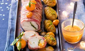 Lotte au lard, un plat festif du carnet de Julie, servi avec des pommes de terre Hasselback et une sauce orangée.