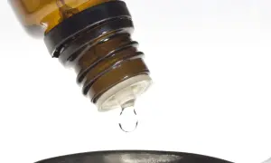 Kropla leku z buteleczki, jak zyrtec krople, spada do naczynia.