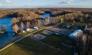 Malownicze **Czechowice jezioro** otoczone lasem, z widokiem na stadninę koni i zabudowania.