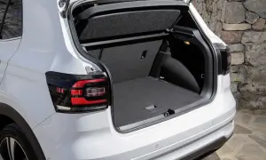 Bagagliaio aperto di un'auto bianca, con un'ampia capacità di carico, perfetta per ogni tipo di viaggio, anche con bagagli di grandi dimensioni.