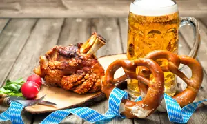 Un saporito stinco di maiale arrosto, due brezel e una birra bionda, un classico cibo da oktoberfest.