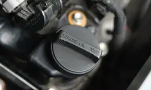 Czarna zakrętka silnika z napisem "ENGINE OIL" i ikonką miarki oleju.