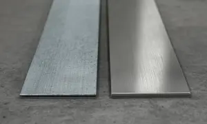 Dwa metalowe paski na szarym tle. Jeden z nich to szorstka stal ocynkowana, drugi gładki metal.