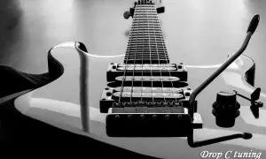 Czarno-białe ujęcie gitary elektrycznej z widocznym gryfem, strunami i przetwornikami. Napis "Drop C tuning" sugeruje specyficzne strojenie instrumentu.