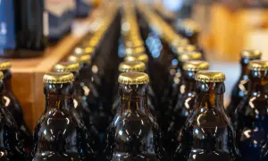 Rzędy ciemnych butelek z złotymi kapslami. Czy kwas chlebowy ma alkohol? To pytanie nurtuje wielu, a te butelki mogą zawierać odpowiedź.
