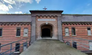 Fort Poznań, dawniej obóz koncentracyjny, z charakterystycznym łukiem i napisem.