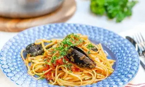 En tallrik med spaghetti allo scoglio, toppad med färska örter och musslor. En härlig italiensk pastarätt.