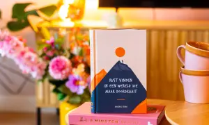 Boek "Rust vinden in een wereld die maar doordraait" op een roze dagboek. Handig voor wie hooggevoelig is en zoekt naar rust.
