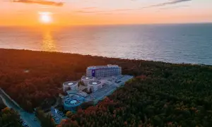 Zachód słońca nad morzem, otaczający las i kompleks hotelowy Hotel Senator Dźwirzyno.