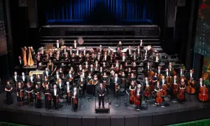 Wielka orkiestra symfoniczna na scenie, muzycy w strojach galowych, dyrygent. To właśnie opera co to za widowisko!