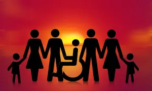 Famiglia unita al tramonto, con un membro su sedia a rotelle. Speranza per una pensione invalidità 800 euro.