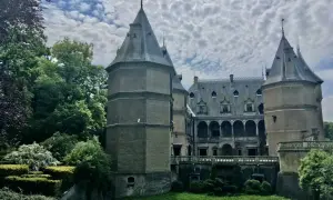 Zamek w Gołuchowie, otoczony zielenią, z wieżami i arkadowym dziedzińcem. Ciekawostki o jego historii i architekturze zachwycają.