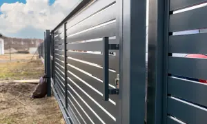 Nowoczesna, ciemnoszara brama przesuwna z poziomymi lamelami. Uchwyt i zamek widoczne. Idealna jako przeciwwaga do bramy 5m.