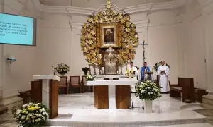 Msza w kościele w Dąbrówce Kościelnej. Trzech duchownych przy ołtarzu, ozdobionym złotym antepedium i obrazem Matki Boskiej.