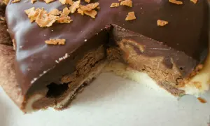 Une part de tarte au chocolat gourmande, avec une ganache onctueuse et des éclats croustillants sur le dessus.