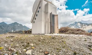 Moderne Kapelle am Pitztaler Gletscher, umgeben von felsiger Landschaft und schneebedeckten Bergen.