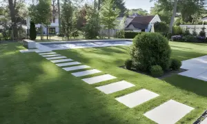 Ścieżka z płyt betonowych prowadzi do basenu w ogrodzie. Dowiedz się, jak zrobić płyty betonowe do ogrodu, by stworzyć podobny efekt.