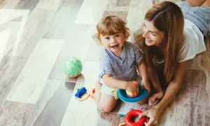 Mama uczy dziecko stawiania granic, bawiąc się z nim na podłodze.