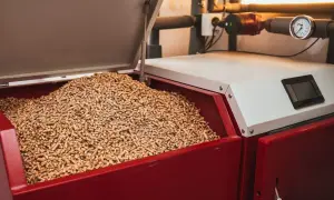 Zbiornik kotła na pellet jest prawie pusty, widać tylko niewielką ilość paliwa.