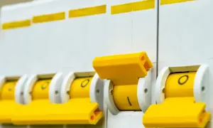 Rząd żółtych wyłączników automatycznych, pokazujący różne rodzaje bezpieczników.