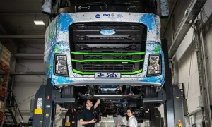 Deux techniciens travaillent sur un camion diesel futuriste, explorant son autonomie et ses innovations.