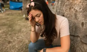 Vrouw met zonnebril op haar hoofd, hand op haar voorhoofd, lijkt te lijden aan een fobie voor naalden.