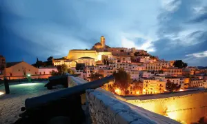Alte Kanonen blicken auf die beleuchtete Altstadt von Ibiza im Winter.