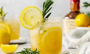 Orzeźwiający limoncello spritz z plasterkami cytryny i gałązką rozmarynu, idealny na letnie popołudnie.
