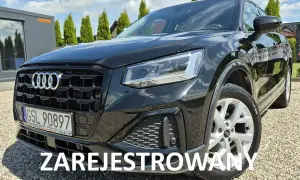 Czarny Audi Q2 na żwirowym podjeździe. Sprawdź atrakcyjną audi q2 cena i zarezerwuj jazdę próbną.