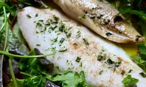 Delizioso merluzzo in friggitrice ad aria, cotto alla perfezione e servito su un letto di insalata fresca.
