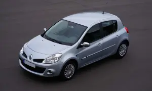 Vue aérienne d'une Renault Clio 3 argentée, modèle à injection, garée sur un sol asphalté.