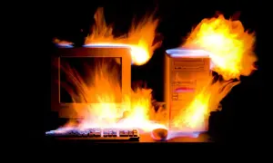 Płonący komputer z lat 2000. i klawiatura, jakby przegrzewały się od emocjonujących, **stare gry na PC lata 2000.**