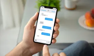 Dłoń trzyma smartfon z widocznym oknem czatu Messenger. Rozmowa dotyczy spotkania. Jak przywrócić wiadomości na Messengerze?