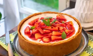 Cheesecake con mascarpone e fragole fresche, guarnita con menta. Un dolce invitante e goloso.