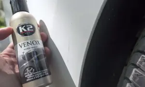 Jak usunąć rysy z samochodu domowym sposobem? Butelka K2 VENOX Scratch remover obok zarysowanego lakieru.