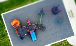 Nowoczesny plac zabaw z pomarańczową zjeżdżalnią i niebieskimi elementami. Czy plac zabaw wymaga pozwolenia na budowę?